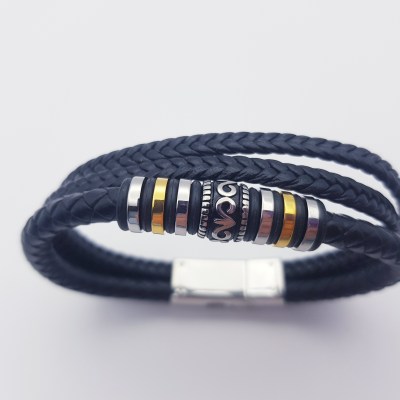 Ascheschmuck Armband mit einem schwarzen Lederband und Edelstahl Elementen in silber, schwarz und gold.