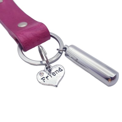 Schlüsselanhänger aus pinkem Leder mit einer Ascheschmuck Kapsel und einem Herz mit der Gravur Friend.